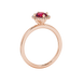 Side profile of a rose gold raspberry red gemstone ring showcasing the French pavé halo design.