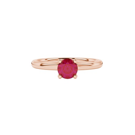 close-up shot of a round raspberry red gemstone ring with a rose gold lotus basket design