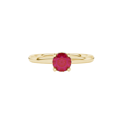 close-up of a round-cut raspberry red gemstone surrounded by a yellow gold diamond pavé basket.
