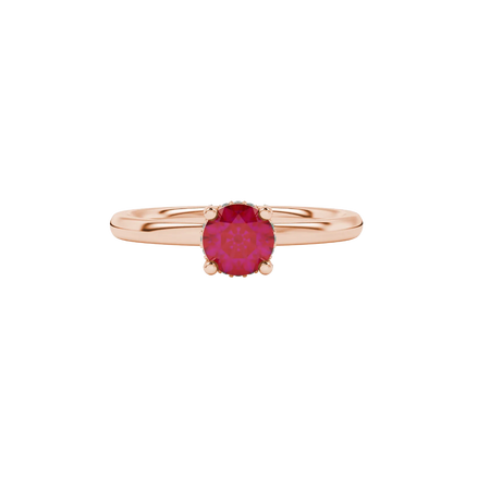 close-up shot of a round raspberry red gemstone ring with a diamond pavé basket in rose gold.