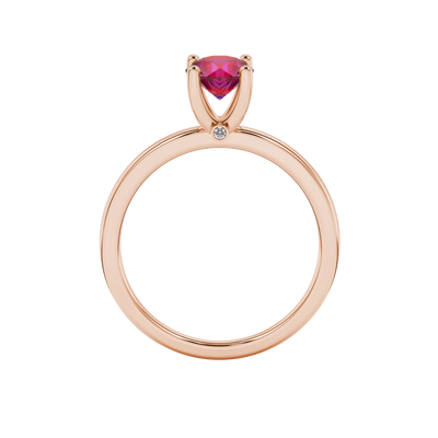 Round-cut raspberry red gemstone solitaire ring in a rose gold surprise diamond setting