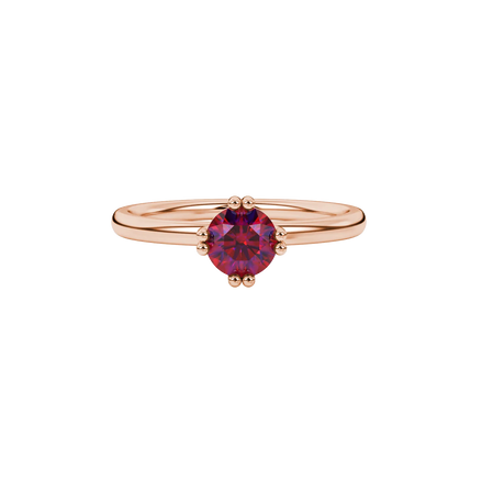 close-up shot of a round raspberry red gemstone ring with a rose gold vintage basket design.