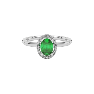 Close-up emerald green gemstone ring, white gold french pavé halo