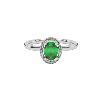 Close-up emerald green gemstone ring, white gold french pavé halo