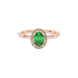 Close-up, oval cut emerald green gemstone ring, rose gold french pavé halo.