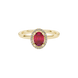 Close-up, oval cut raspberry red gemstone, yellow gold french pavé halo ring.