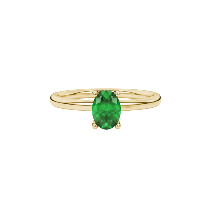 Close-up, oval cut emerald green gemstone, yellow gold surprise diamond ring.