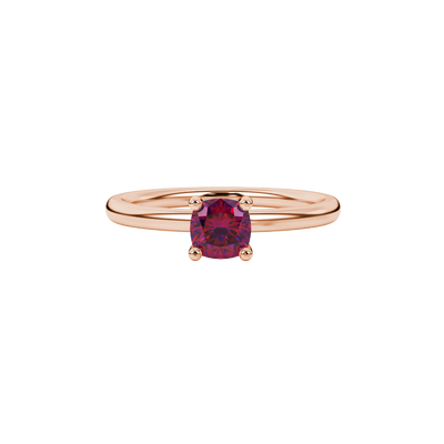 Red cushion cut gemstone solitaire ring in gold featuring a refined four-prong cathedral basket setting
