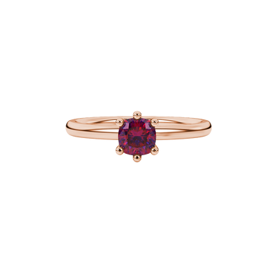 Red cushion cut gemstone solitaire ring in gold featuring a six-prong crown basket setting