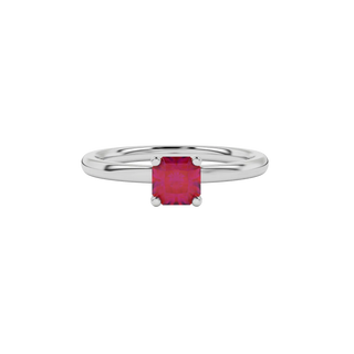 close-up of a radiant raspberry red gemstone enclosed in a white gold four-prong ring setting.