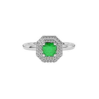 Close-up details of a radiant emerald green gemstone secured in a white gold falling edge halo ring.