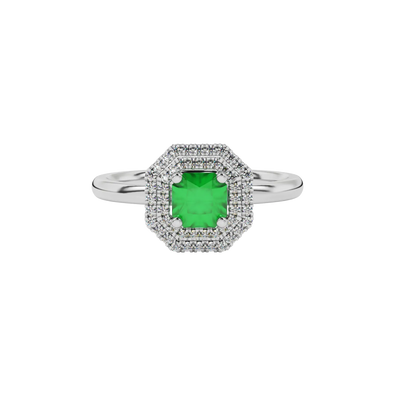 Close-up details of a radiant emerald green gemstone secured in a white gold falling edge halo ring.