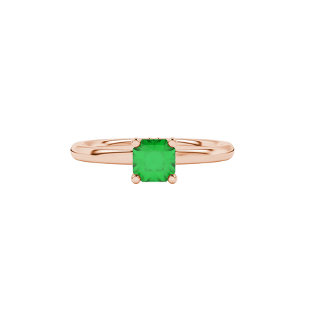 close-up shot of a radiant emerald green gemstone ring with a rose gold lotus basket gallery.