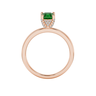 Radiant-cut emerald green gemstone solitaire ring in a rose gold pavé basket setting.