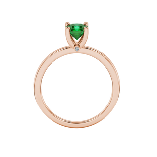 Radiant-cut emerald green gemstone solitaire ring in a rose gold surprise sapphire setting