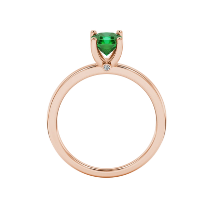 Radiant-cut emerald green gemstone solitaire ring in a rose gold surprise sapphire setting