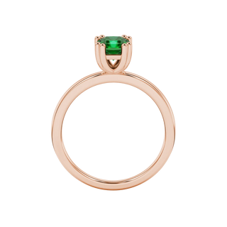 Radiant-cut emerald green gemstone solitaire ring in a rose gold vintage basket setting.