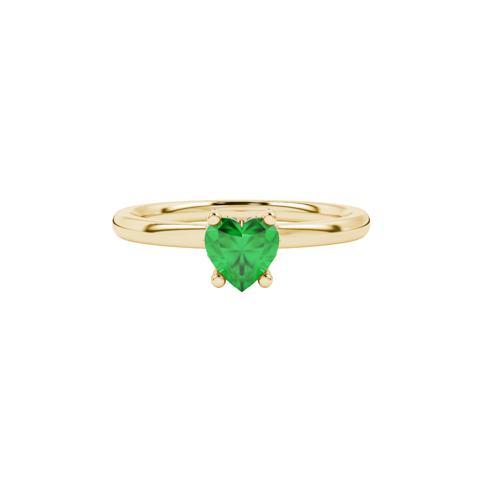 close-up of a heart-shaped emerald green gemstone secured in a yellow gold