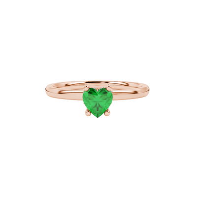 Close-up heart-shaped emerald green solitaire gemstone with a diamond pavé basket in rose gold.