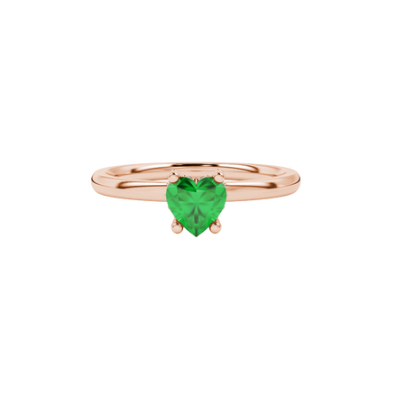 Close-up heart-shaped emerald green solitaire gemstone with a diamond pavé basket in rose gold.