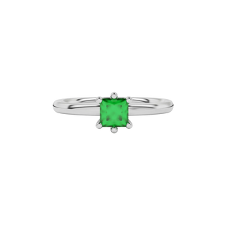 Close-up emerald green gemstone ring, white gold six-prong setting.