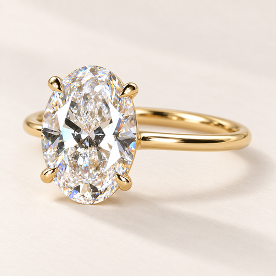 Oval cut lab grown diamond four-prong engagement ring in yellow gold with individual claw tips and a plain polished band