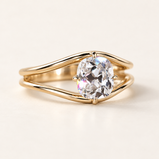 Cushion old mine cut lab grown diamond split shank engagement ring in yellow gold with two curved arms and four tapered prongs