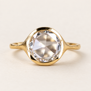 Round rose cut lab grown diamond bezel engagement ring in yellow gold with a continuous rim and textured tapered shoulders
