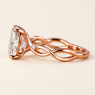 Elongated cushion Lab Grown Diamond cathedral engagement ring in rose gold with a twisted vine shank and two round accents.