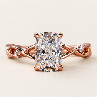 Elongated cushion Lab Grown Diamond cathedral engagement ring in rose gold with a twisted vine shank and two round accents.