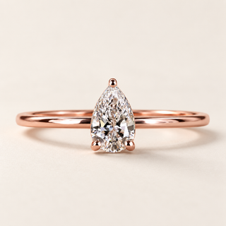 Pear cut lab grown diamond solitaire engagement ring in rose gold with three rounded prongs and a plain polished band