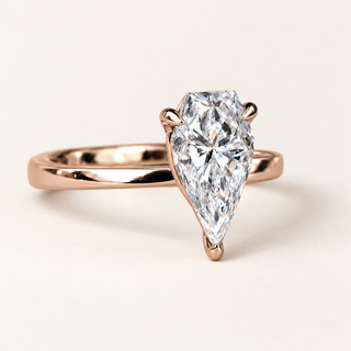 Spear cut lab grown diamond solitaire engagement ring in rose gold with two upper claws, a rounded point prong and a plain band