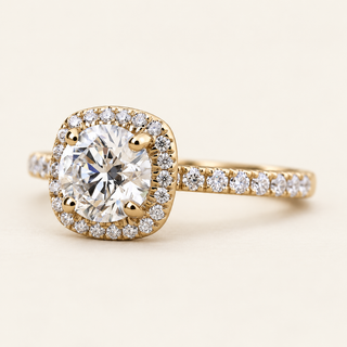 Round lab grown diamond engagement ring in yellow gold with cushion-shaped pavé halo, four-prong center and diamond shoulders