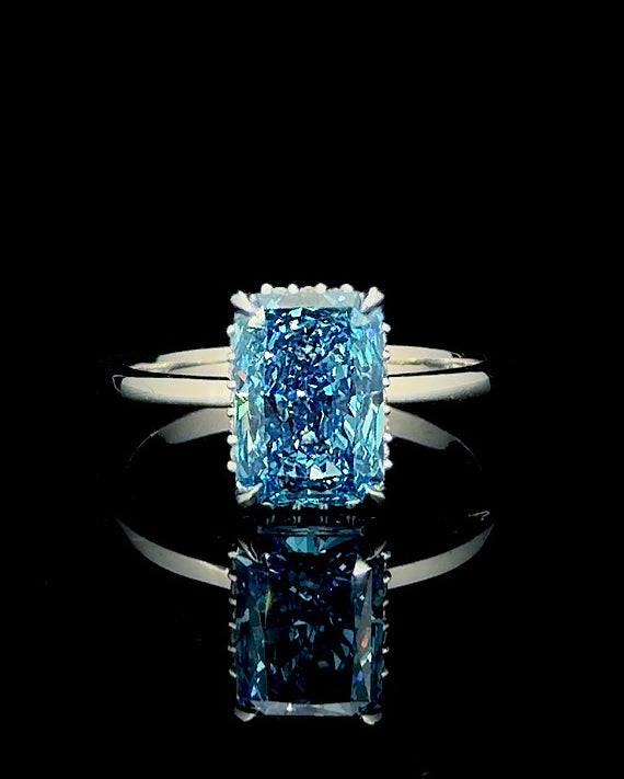 Main: White gold 2.99ct blue radiant hidden halo ring with lab grown diamonds on black
Detail: Close-up of 2.99ct blue radiant lab grown diamond in a four-prong white gold setting
Side: White gold blue radiant ring showing 0.11ct lab grown diamond hidden halo beneath the centre