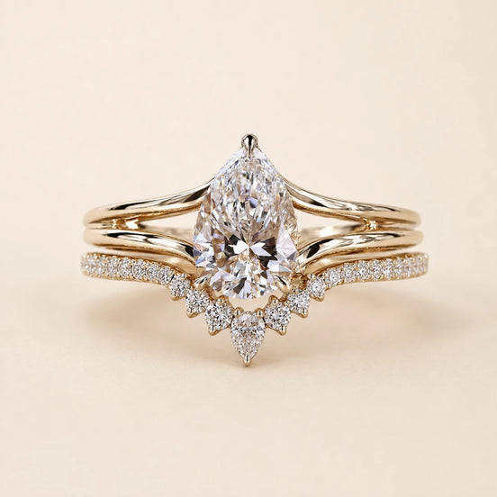 Pear Lab Grown Diamond bridal ring set in yellow gold featuring a cathedral solitaire engagement ring with a tiara contour wedding band.