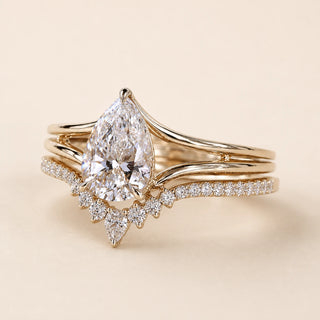 Pear Lab Grown Diamond bridal ring set in yellow gold featuring a cathedral solitaire engagement ring with a tiara contour wedding band.
