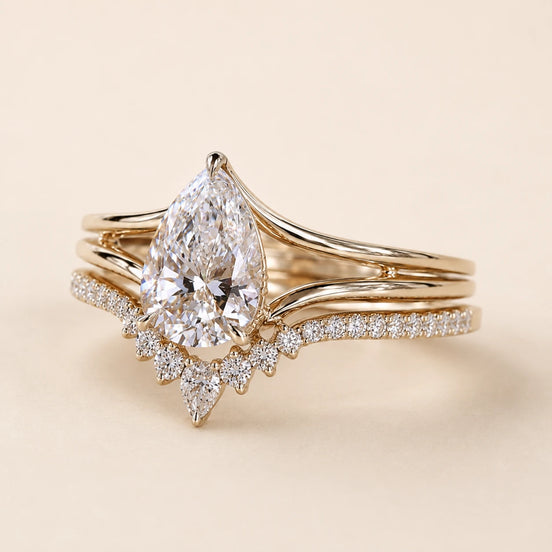 Pear Lab Grown Diamond bridal ring set in yellow gold featuring a cathedral solitaire engagement ring with a tiara contour wedding band.