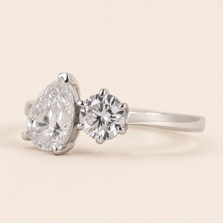 Pear cut and round Lab Grown Diamond two-stone bypass engagement ring in white gold with four-prong open baskets.