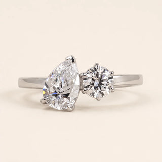 Pear cut and round Lab Grown Diamond two-stone bypass engagement ring in white gold with four-prong open baskets.