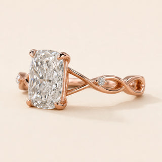 Elongated cushion Lab Grown Diamond cathedral engagement ring in rose gold with a twisted vine shank and two round accents.