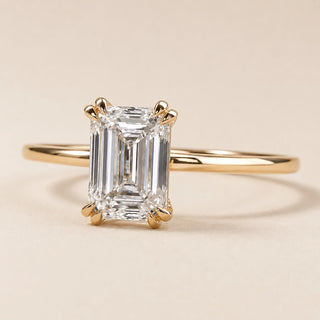 Emerald cut Lab Grown Diamond solitaire engagement ring in yellow gold with a double-claw four-prong cathedral setting.