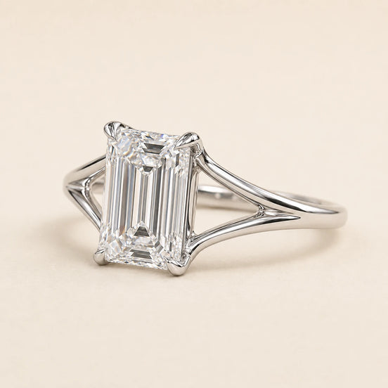Emerald cut Lab Grown Diamond split shank engagement ring in white gold with a four double-claw prong cathedral setting.