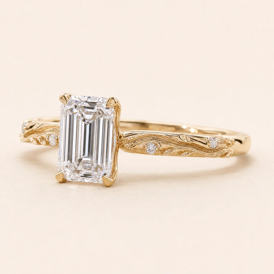Emerald cut Lab Grown Diamond vintage engagement ring in yellow gold with a double-claw cathedral basket and engraved shank.