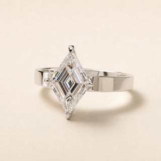 Lozenge step cut Lab Grown Diamond solitaire enLozenge step cut Lab Grown Diamond solitaire engagement ring in white gold with double-claw prongs and a wide knife-edge shank. shank.