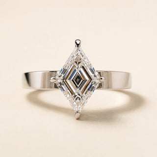 Lozenge step cut Lab Grown Diamond solitaire engagement ring in white gold with double-claw prongs and a wide knife-edge shank.
