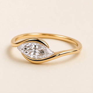 Marquise Lab Grown Diamond east-west solitaire engagement ring in yellow gold with a half-bezel bypass setting.