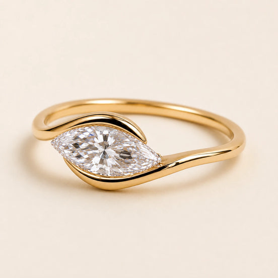 Marquise Lab Grown Diamond east-west solitaire engagement ring in yellow gold with a half-bezel bypass setting.