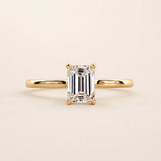Emerald cut Lab Grown Diamond solitaire engagement ring in yellow gold with a four-prong cathedral open basket setting.