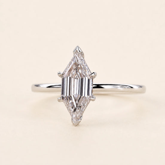 Long hexagon step cut Lab Grown Diamond solitaire engagement ring in white gold with a four-prong cathedral open basket.