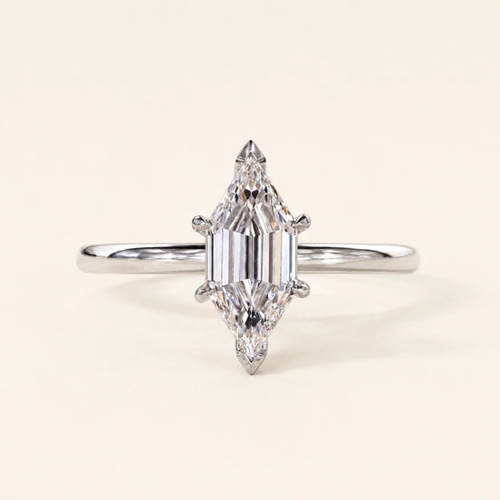 Long hexagon step cut Lab Grown Diamond solitaire engagement ring in white gold with a four-prong cathedral open basket.